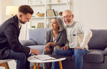 Real estate agent helps to happy senior couple regarding property real estate. Help from realtor to...