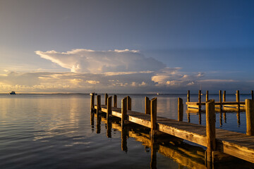 Sunset begins to fall over a wooden boat dock in  the Gulf of Mexico on Key Largo in the Florida Keys