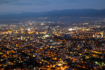 Night city panorama with illuminated buildings. Aerial view of a modern city at night. Night panorama urban silhouettes, a symphony of lights. The city seen from above.