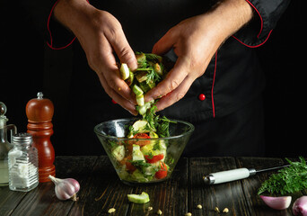 A chef hands stir vegetables in a bowl while preparing a vitamin-packed breakfast salad.