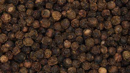 Texture of black peppercorns. Brown photo of pepper spice background