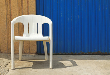 silla blanca de plástico frente a una puerta azul de garaje cabo de gata almería 4M0A2869-as24