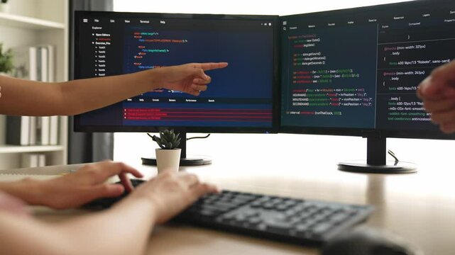 Slow motion back end software developer engineer for computer programming working together on debugging writing computing code, solving complex algorithms display on monitor in office. Burgeoning