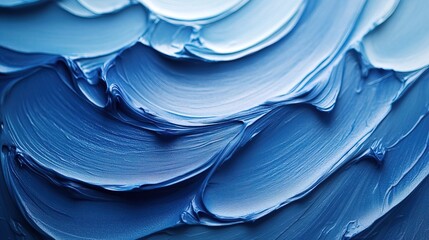 Abstract close-up of textured blue cream or paint with smooth, wave-like grooves and ridges 