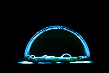 Blue drop of water in the darkness, isolated objects 