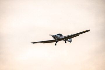Small plane flying with sunset light in a blue sky. Light plane.