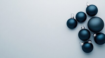   A set of blue Christmas ornaments rests atop a white table beside two blue and white walls