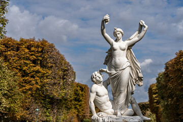 Fototapeta premium Standing topless woman with sitting man white stone statue in Paris
