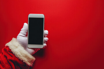 Santa Claus holding a phone, smiling.