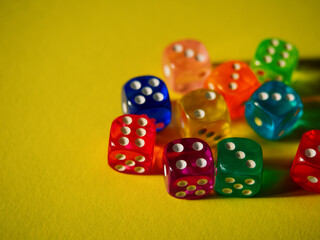 Color dices on yellow paper background. Cardboard bright background with texture. Concept of luck, testing fate, lottery, decision making. Place for text. Copy space. Rovinj, Croatia - October 4, 2024