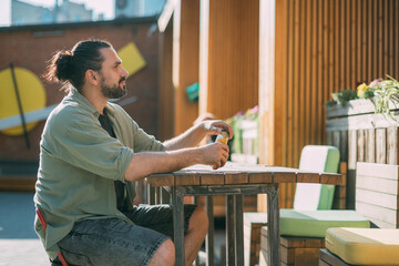 A young white man on a street food court in a modern urban space. Fast food, street food.