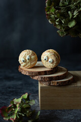 Funny spooky french macarons beige with eyes on dark background with spiders and spider net