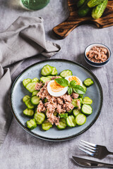 Keto salad with tuna, cucumber, egg and basil in a bowl on the table vertical view