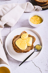 Delicious toasts with honey butter on a plate on the table vertical view