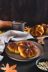 Sweet pumpkin buns on a plate on the table vertical view