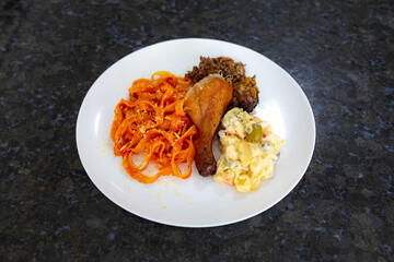 Traditional Brazilian Sunday lunch, pasta, roast chicken and mayonnaise salad with potatoes