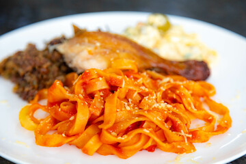 Traditional Brazilian Sunday lunch, pasta, roast chicken and mayonnaise salad with potatoes