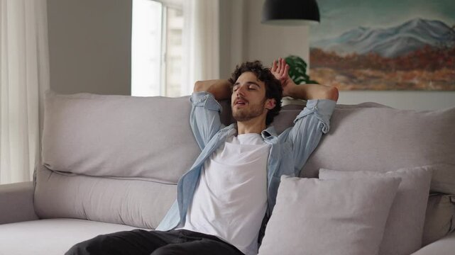 Happy relaxed young man rest lounge lean on couch enjoy peaceful mood, healthy lazy calm guy dreaming breathing fresh air sit on comfortable sofa in living room on stress free cozy day at home
 - Powered by Adobe
