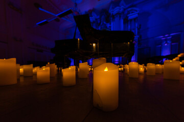blurred symphonic orchestra on stage with lots of candles