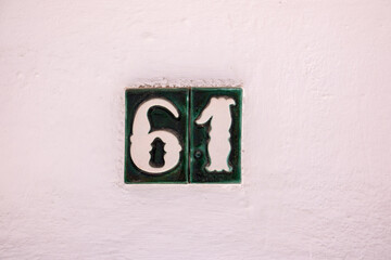 Beautiful house number 61 in Spanish style. House number on a ceramic patterned base in the old...
