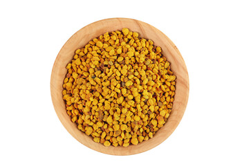 Bee pollen grains in wooden bowl isolated on white background. Top view. Flat lay