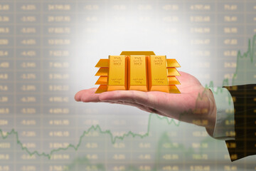 Trading gold on stock exchange. Miniature golden bars in hand of investor. Gold price growth chart....