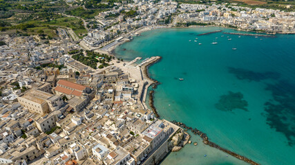 Naklejka premium Aerial view of the historic center of Otranto in the province of Lecce, Salento, Puglia, Italy. You can see the cathedral of the town and in the background the Mediterranean Sea.