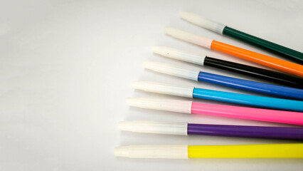 Colorful markers arranged on a white background