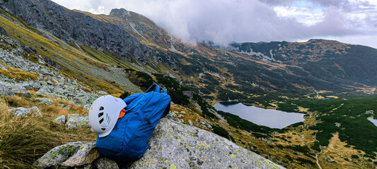 Hiking backpack for travel and helmet for climbing mountains. Traveling in the mountains. Hiking in...