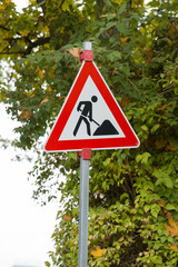 Temporary repairs: improvement of urban infrastructure. A road sign warning drivers about upcoming...
