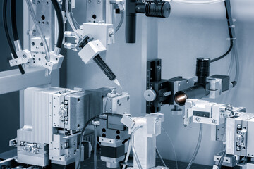 A machine with a lot of wires and tubes is in the middle of a room. The machine is surrounded by other machines and wires. The room is filled with a sense of technology and innovation