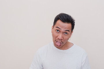 Funny and ugly face Southeast Asian man in white t-shirt on isolated white background.