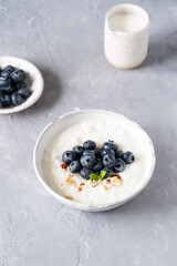 Rice porridge on coconut milk with blueberries on a gray background. Healthy breakfast, healthy food