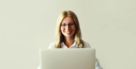 Naklejka premium Happy woman working with laptop sitting at desk in office or home