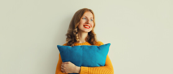 Healthy sleep, happy woman hugs her soft comfortable pillow imagining that she is lying on the bed