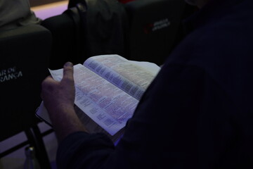 Close-up of a man's hands holding a Holy Bible, symbolizing faith and devotion. The image captures the essence of spirituality and reflection, inviting a deeper connection to religious traditions.