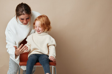 Generations united woman and little girl sitting together on chair in family portrait at home