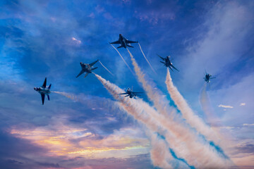 Six military jets fly through cloudy skies trailing smoke behind them