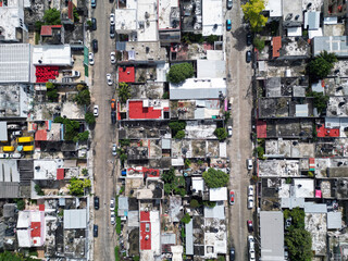 Aerial top-down view high altitude of slum, a heavily populated urban informal settlement characterised by substandard housing and squalor poor living conditions streets and rusty metal home roof tops