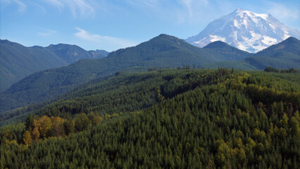 Aerial view of forested mountains with Mount Rainier in the distance, Washington State, USA