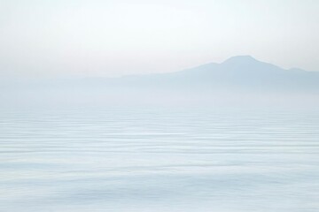 Silhouetted Mountain Range Over Foggy Lake