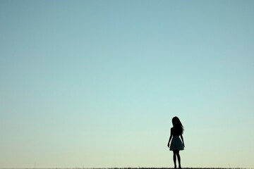 Silhouette of a Woman Standing Against a Clear Sky