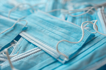 Many sterile medical blue disposable masks. Stack of new medical masks organized.