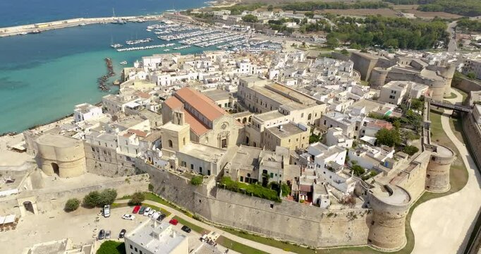 Aerial view of the Cathedral of Santa Maria Annunziata located in Otranto, Salento, Puglia, Italy. It is a minor basilica in the historic center of the town. In background is the Adriatic Sea and port