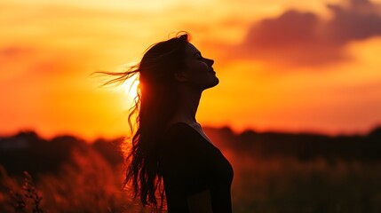 Naklejka premium Happy woman standing with her back on sunset in nature.