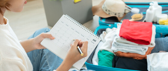 Holiday calendar for travel, Traveler, travel bag. choose country for travel. Asian Young women are prepare clothes and personal belongings. Pack your luggage before travel, Travel, life style © Shisu_ka
