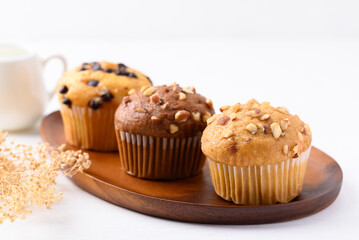 Vanilla almond muffin, Chocolate almond muffin and Vanilla chocolate chips muffin on wooden plate