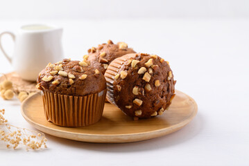 Chocolate almond muffin on wooden plate with white background