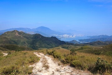 Scenic Pathway Through Rolling Hills Under Clear Blue Sky
