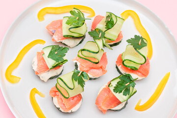 Canapes without Bread with Fresh Salmon, Cucumber and Cream Cheese on White Plate. Easy Breakfast. Diet Food. Quick and Healthy Sandwiches. Healthy Snacks with Tasty Fillings